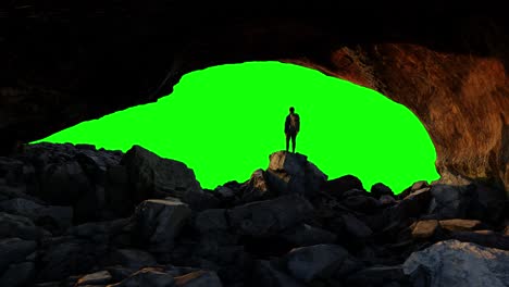 Adventure-Man-Hiker-standing,-looking-out-in-Rocky-cave-on-top-of-Mountain