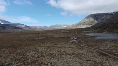 hombre solitario de mochila haciendo senderismo en el paisaje de la tundra escandinava de otoño con una mochila grande