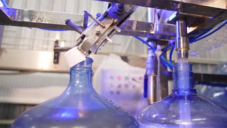 automated line for water production. big bottles are filled with clean water at the food factory. close up.
