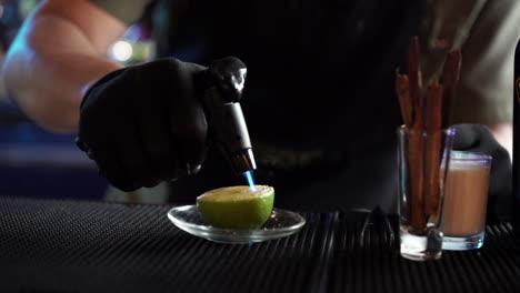 bartender-flaming-torching-torch-lemon-for-cocktail-garnish-slow-motion