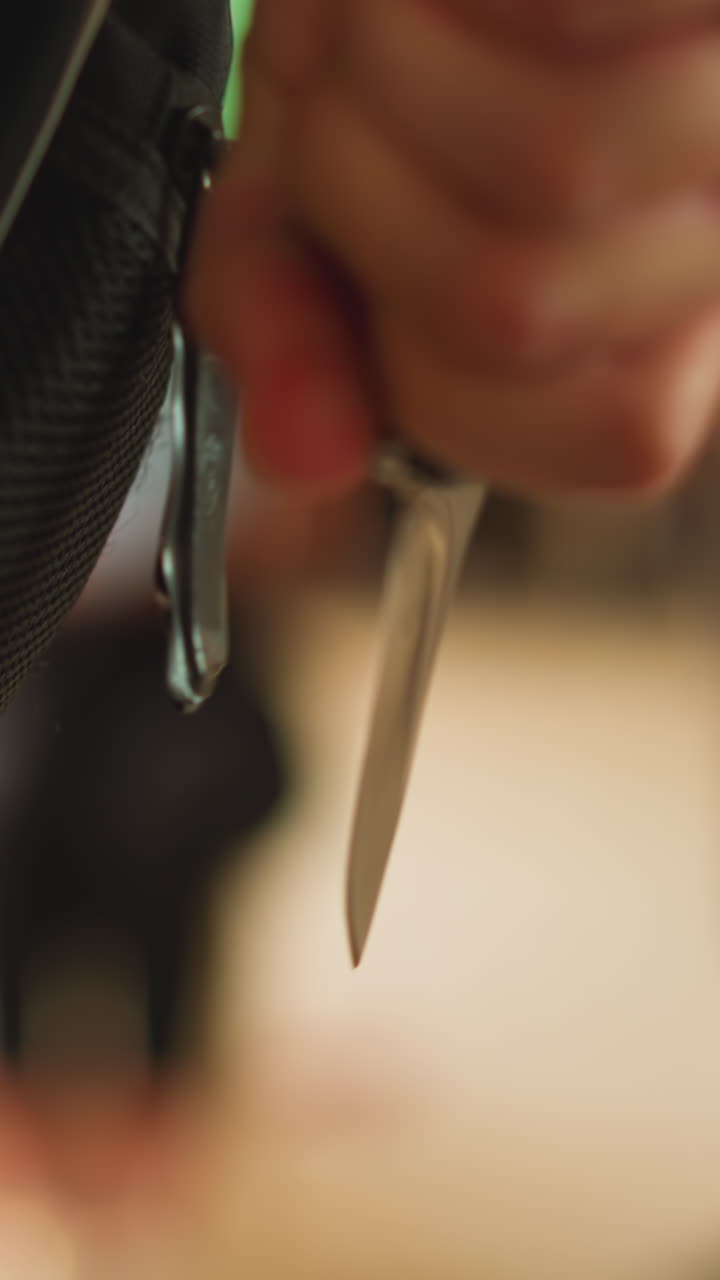 Man takes knife off casing ready to attack criminals and save victim on blurred background in light space close backside view slow motion