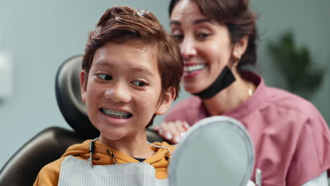 niño sonriendo al dentista mostrando sus aparatos ortopédicos