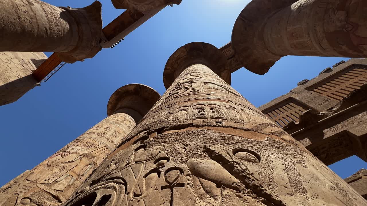 Low-angle close up of hieroglyphics carved into the massive columns of the Great Hypostyle Hall at Karnak Temple, Luxor, Egypt. For history or travel use