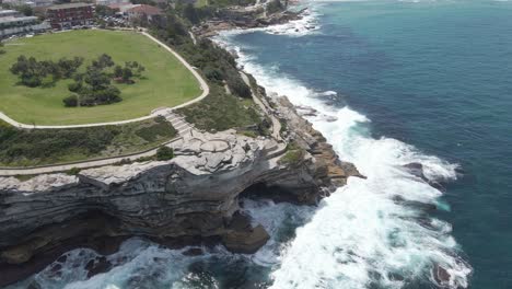 cliffs of mackenzies point peninsula hit by dangerous waves - coastal walk around marks park in tamarama, nsw, australia