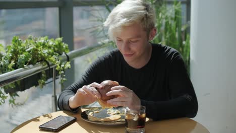 hombre comiendo una hamburguesa