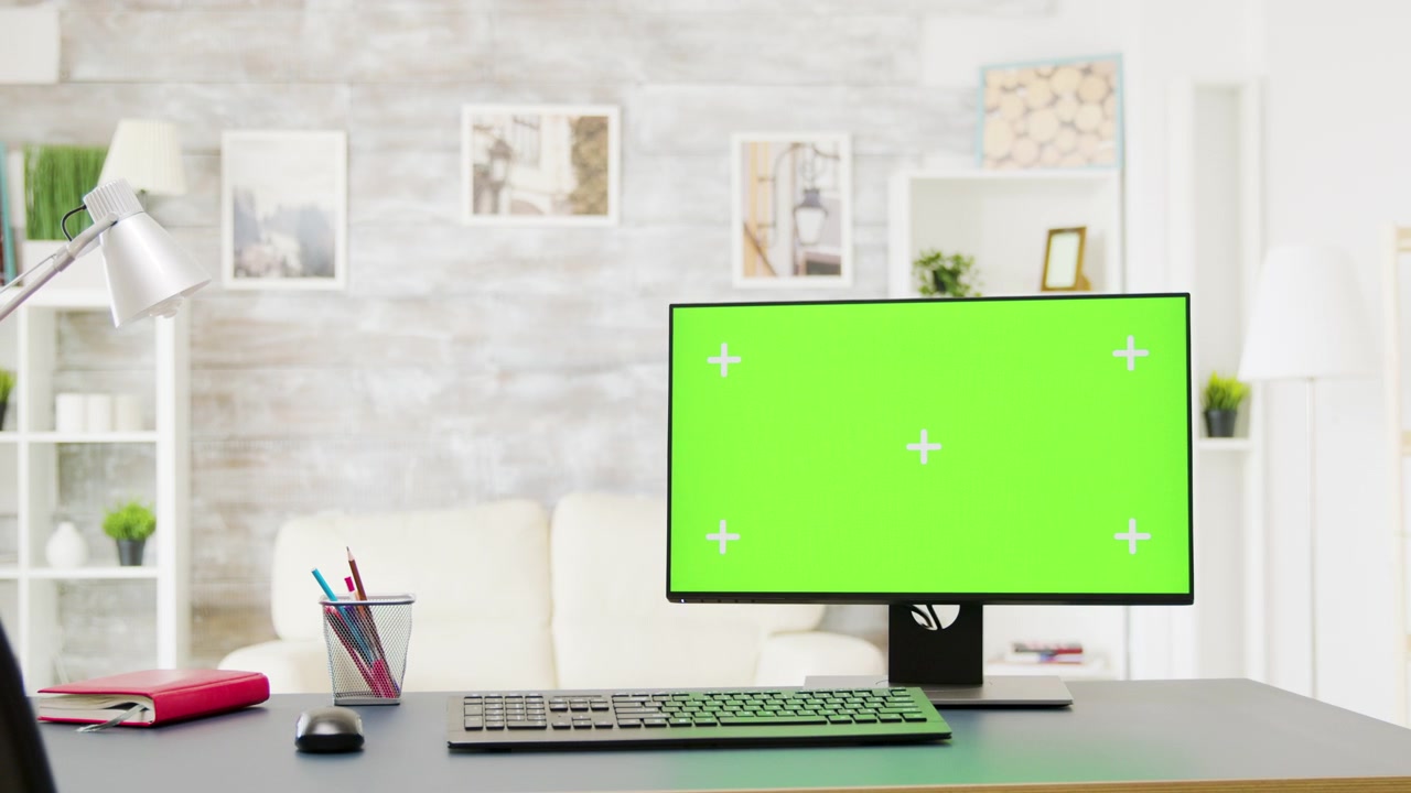 Computer Monitor With Green Screen on Desk in Home Office