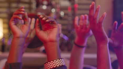 Close-Up-Of-Unrecognizable-Multiethnic-Friends-Moving-Their-Raised-Hands-In-The-Air-While-Lying-On-The-Floor-During-Rehearsal-In-Recording-Studio-2