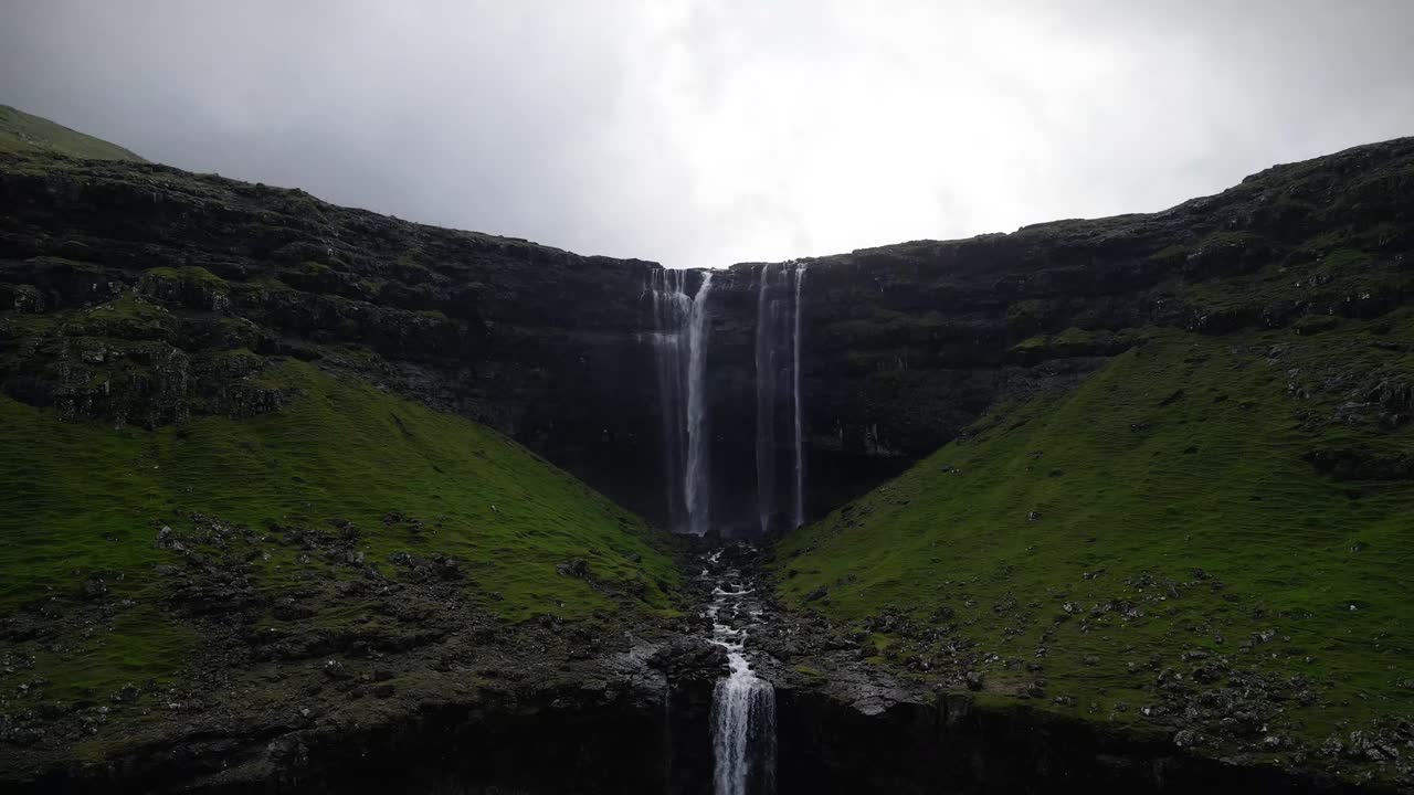 la cascada de fossa, la más alta de las islas feroe, se sumerge dramáticamente en un desfiladero rocoso, creando un espectáculo natural impresionante con su agua en cascada.