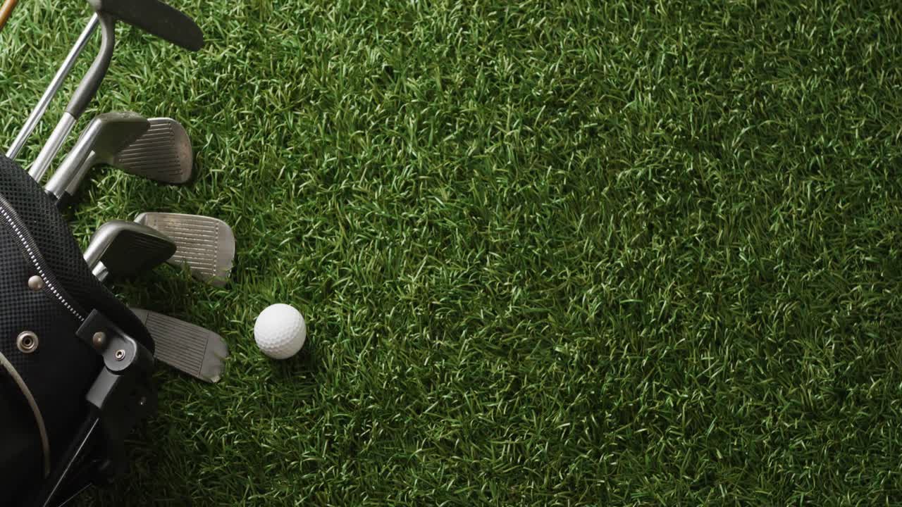 Primo piano di mazze da golf e pallina sull'erba, spazio per il testo, movimento rallentato.