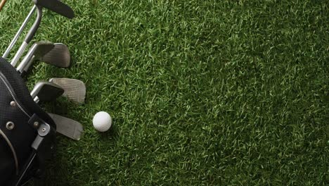 Close-up-of-golf-clubs-and-ball-on-grass,-copy-space,-slow-motion