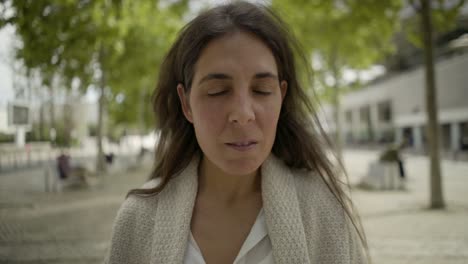 relaxed mature woman walking on street and talking to camera.