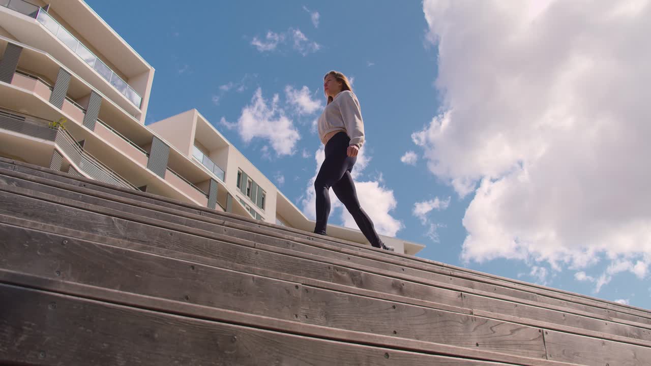 una mujer haciendo un ejercicio de sentadilla dividida durante el día