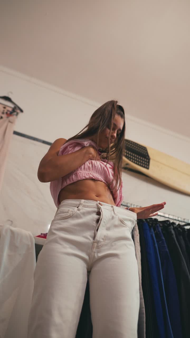 A woman trying on clothes in a dressing room