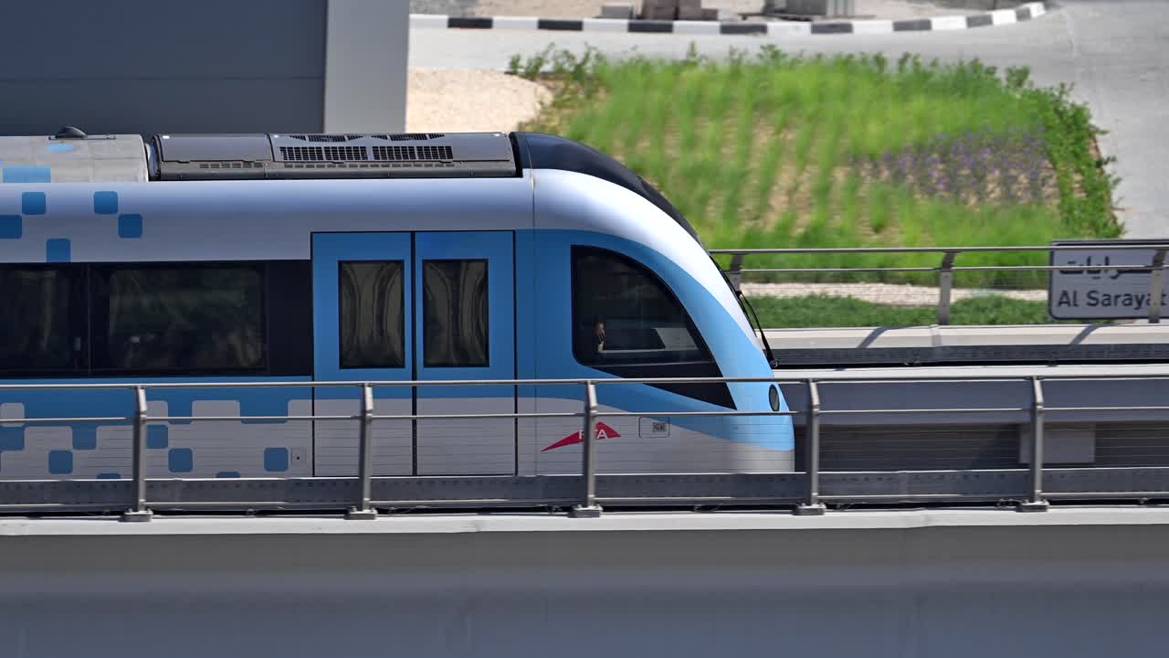A close-up of a Dubai Metro train as it heads to its next stop along Sheikh Zayed Road in Dubai, UAE