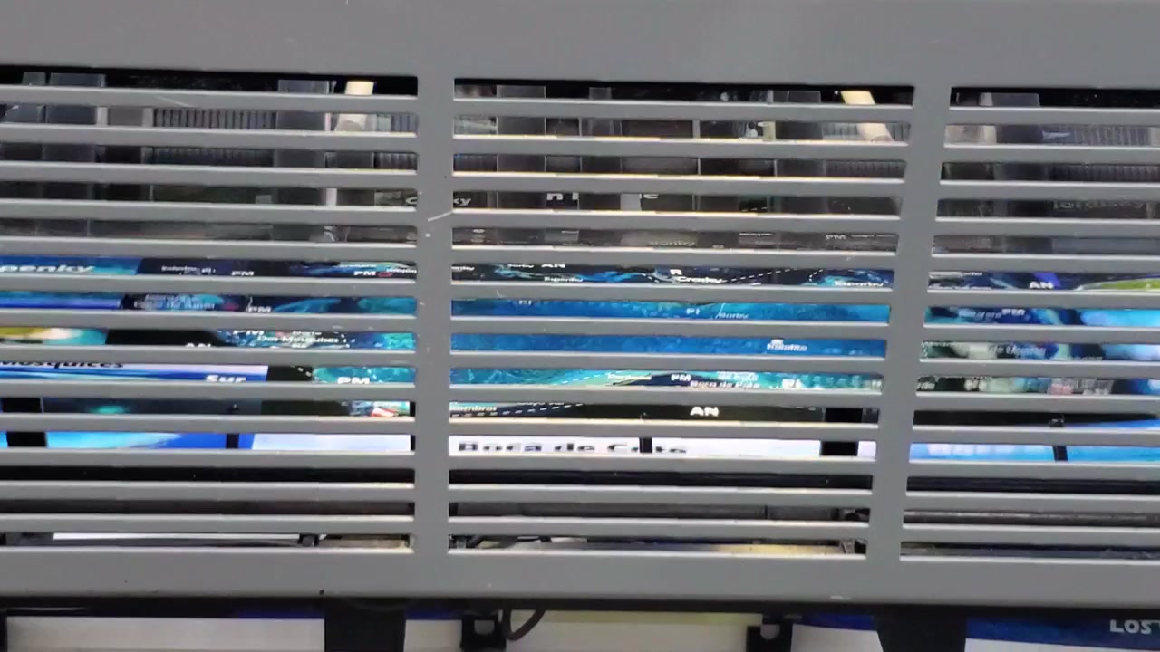 View through a security metal grate of a fast rotary printing mechanism processing paper sheets at a manufacturing plant.
