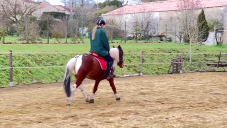 Niña-Montando-Su-Pony-En-El-Paddock