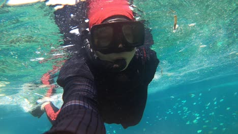 pov shot of young attractive woman snorkeling in tropical ocean water, summer vacation fun