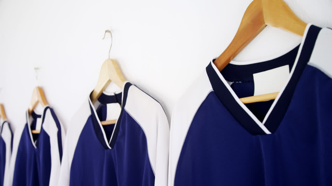 camiseta colgada en una percha contra un fondo blanco 4k