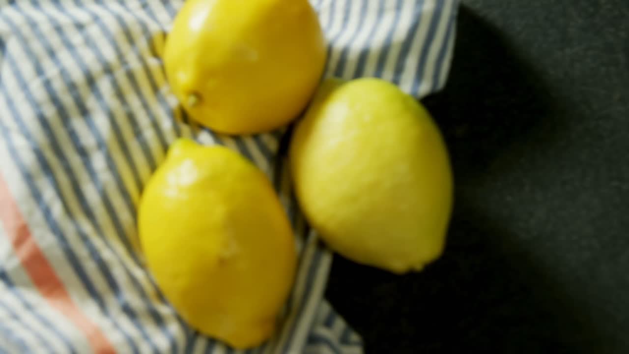 Lemon with a cloth on black background 4k