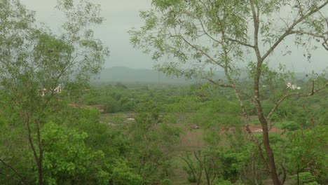 A-serene-view-of-lush-green-countryside-with-distant-hills-and-scattered-houses