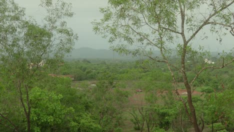a serene view of lush green countryside with distant hills and scattered houses