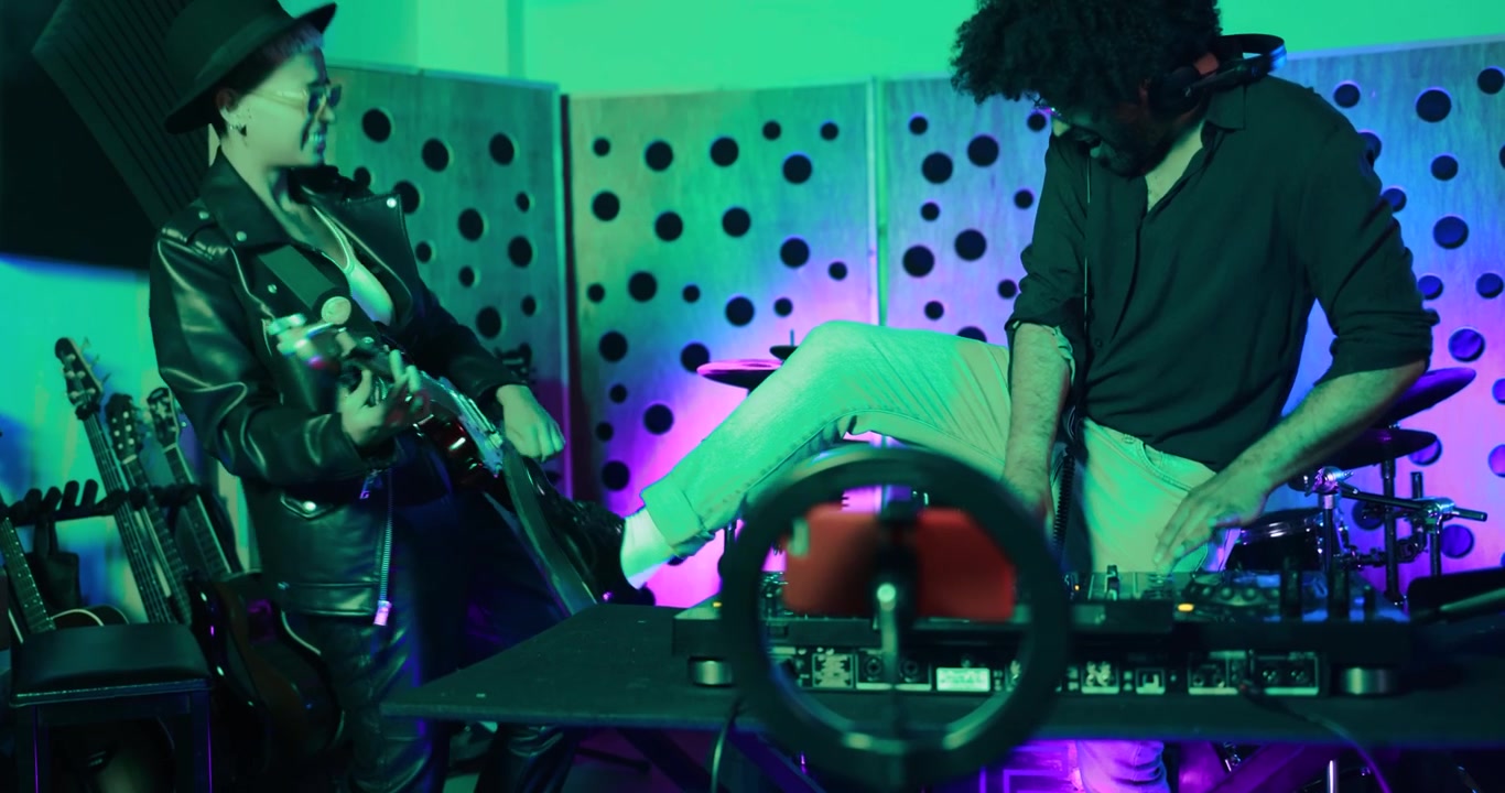 Musicians Playing Electric Guitar and DJing in a Neon Lit Studio