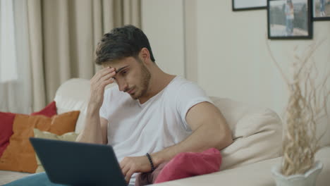 Worried-business-man-working-on-laptop-computer-at-couch.-Upset-man