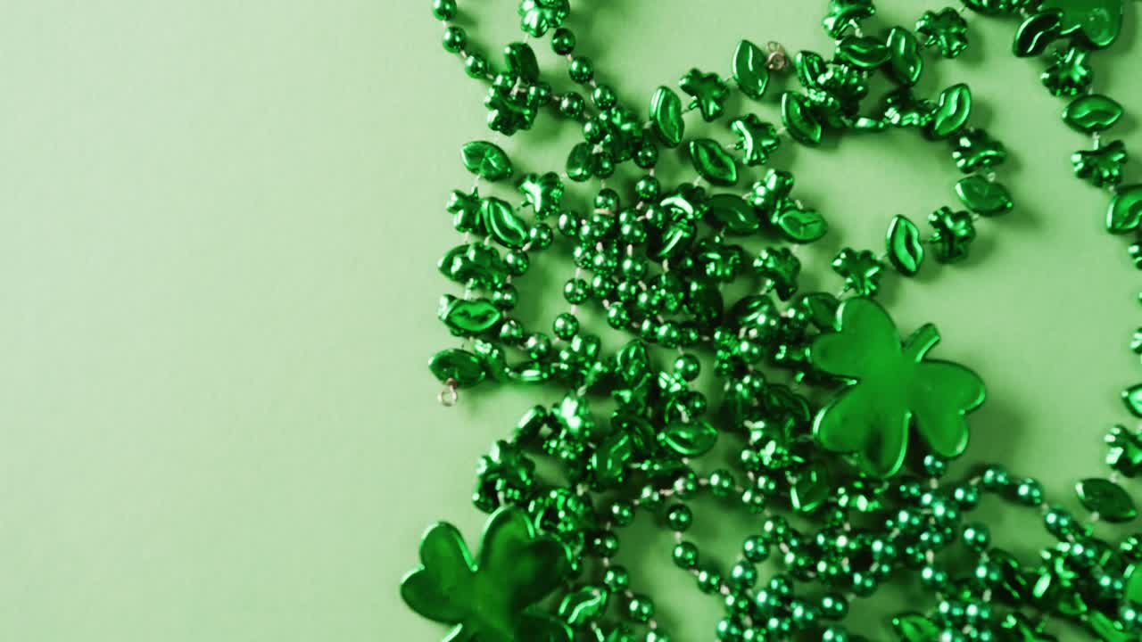 Video of st patrick's green shamrock and necklace on green background