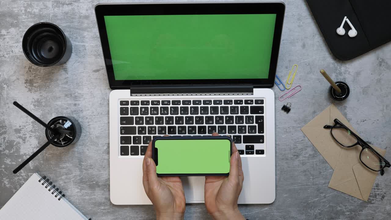 mujer trabaja usando varios dispositivos portátil y teléfono inteligente con pantalla verde. joven mujer creativa trabajando en una maqueta de portátil mientras está sentada en el escritorio de la oficina. lugar de trabajo moderno. llave de croma