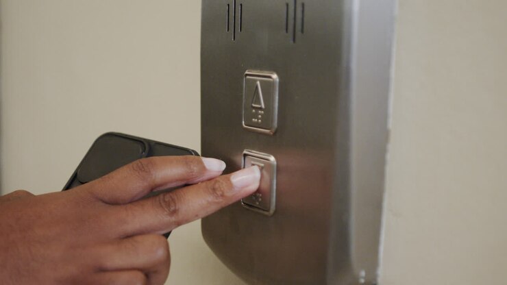 Happy african american casual businesswoman talking on smartphone standing in elevator, slow motion