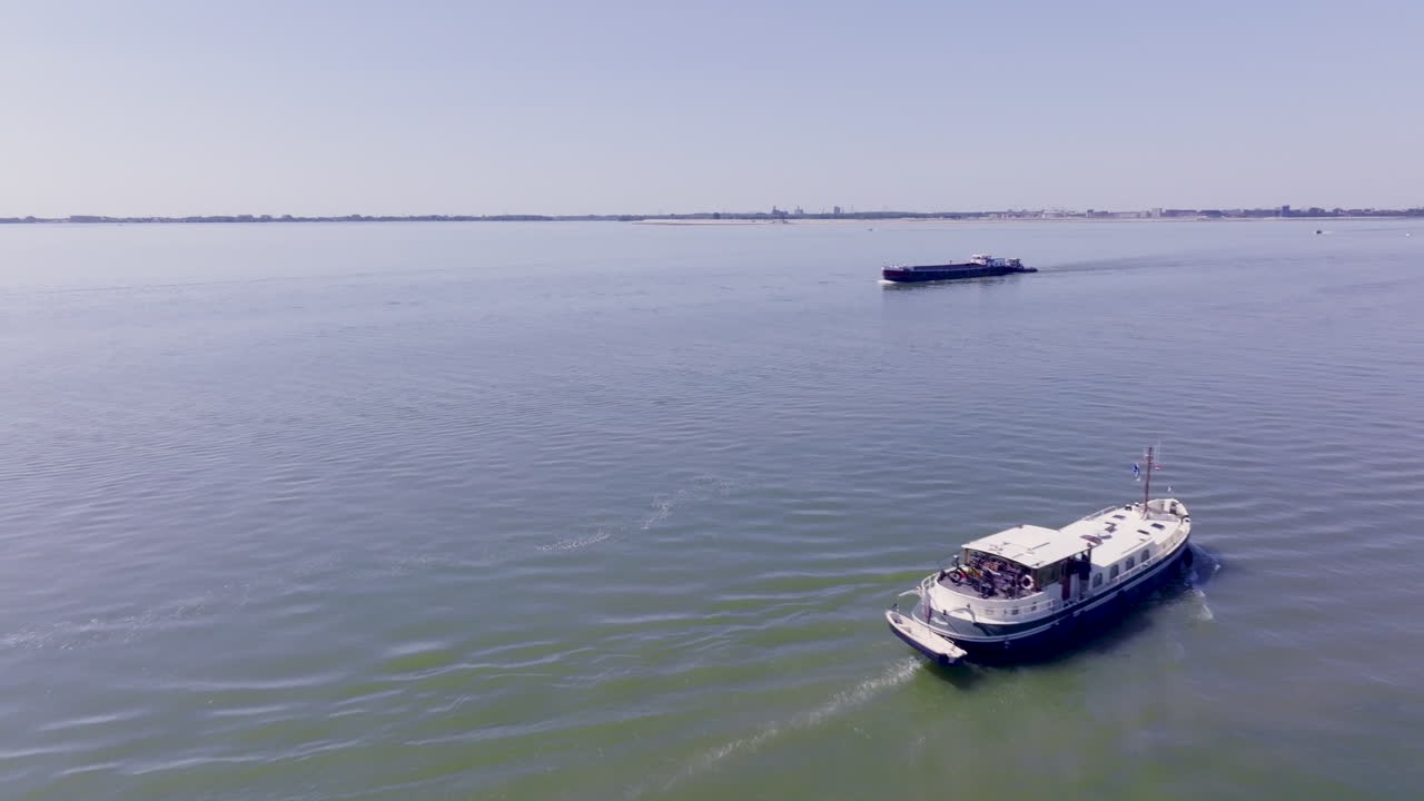 A peaceful aerial view of a Luxemotor Dutch boat gliding across the calm waters of Flevoland in the Netherlands