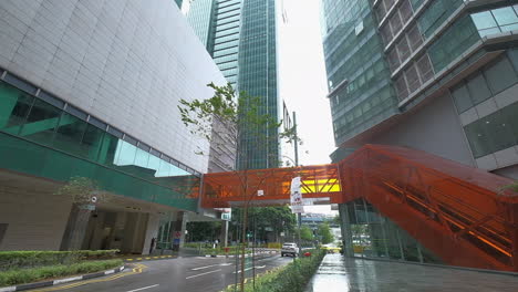 cityscape with modern architecture and pedestrian bridge in rain