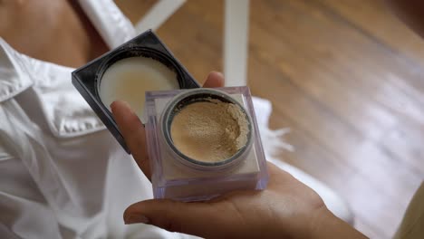 Applying-powder-with-a-brush-from-a-cosmetic-compact-in-hand