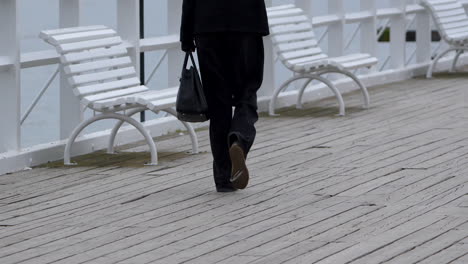 Mujer-Vestida-Corporativa-Caminando-En-Cámara-Lenta-En-El-Paseo-Marítimo-De-Madera-De-La-Playa