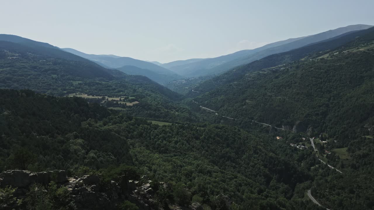 Breathtaking aerial perspective reveals the stunning pyrenees mountains in catalonia, spain, showcasing lush green valleys and a winding road