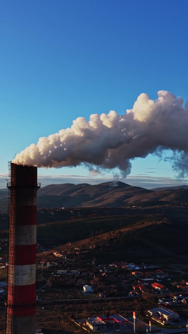 Eruzione vulcanica che sprigiona cenere e fumo nel cielo sopra le montagne e la città