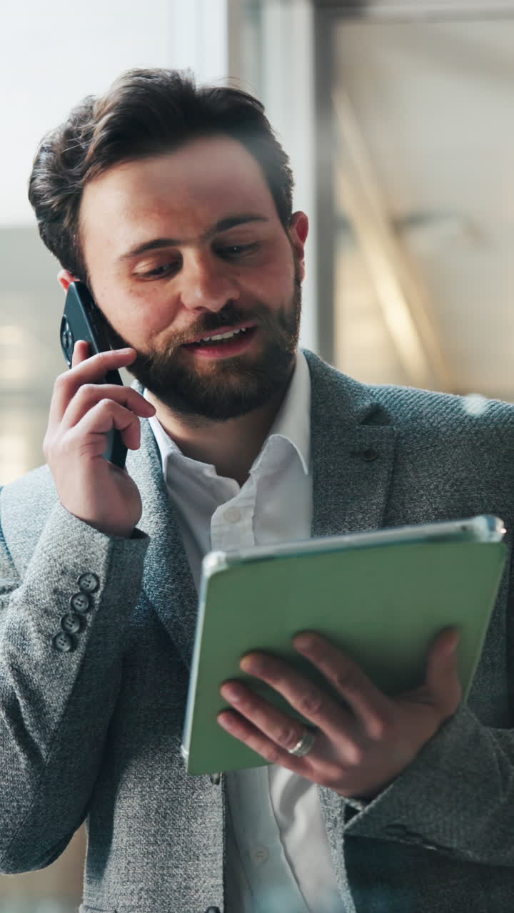 Bearded Man Talking on Phone and Using Tablet