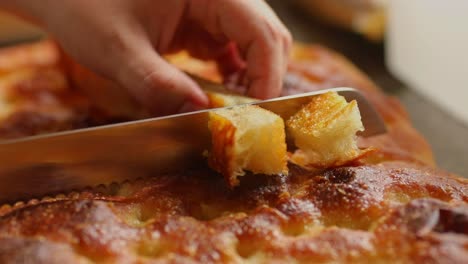 Cutting-bread-made-from-organic-cassava-flour-into-bite-size-servings---isolated-close-up