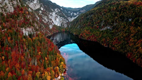 drone shot overlooking stunning red foliage at lake toplitzsee, in austria