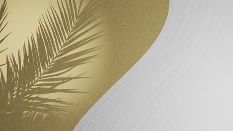 White-plaster-wave-by-golden-texture-background-with-palm-frond-shadow