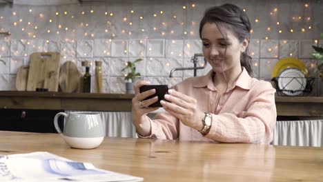 woman using phone in cozy kitchen