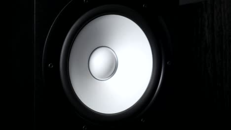 close up of moving sub-woofer on recording studio. white speaker pulsating and vibrating from listening of loud music on low frequency. work of modern high fidelity loudspeaker membrane. slow motion