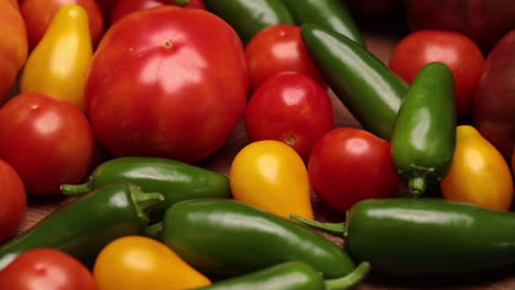 Flat-lay-on-rustic-aged-pallet-wood-Cherokee-purple-tomato-Jalapeno-pepper-red-and-yellow-tomatoes-cayenne-and-yellow-pepper-with-hardwood-cutting-board