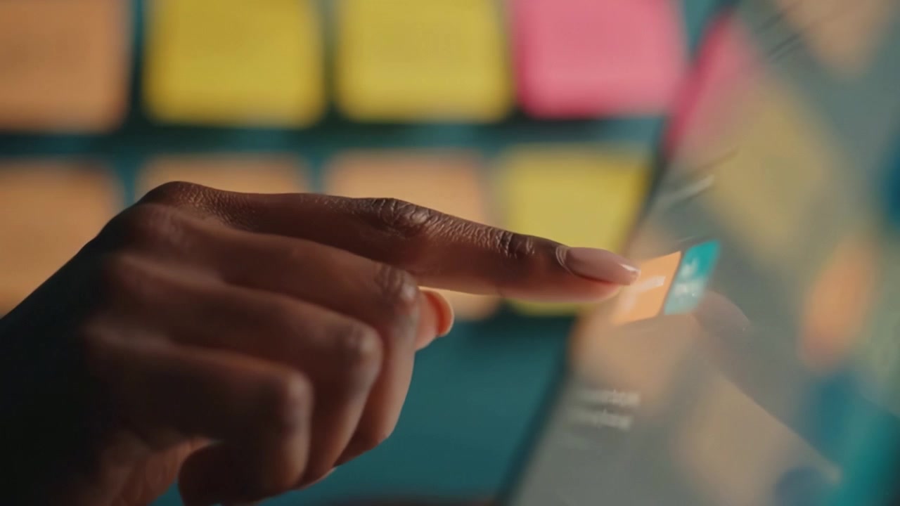 Dynamic Interaction: Close-up of Finger Tapping on a Tablet Screen Surrounded by Colorful Sticky Notes, Demonstrating Digital Engagement and Productivity.