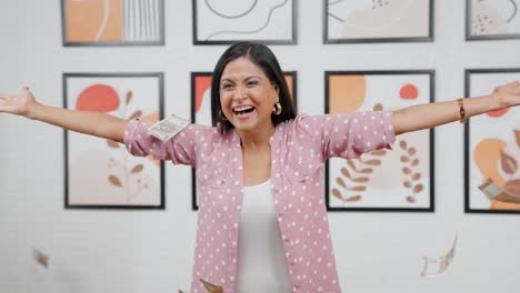 modern indian woman throwing money in air