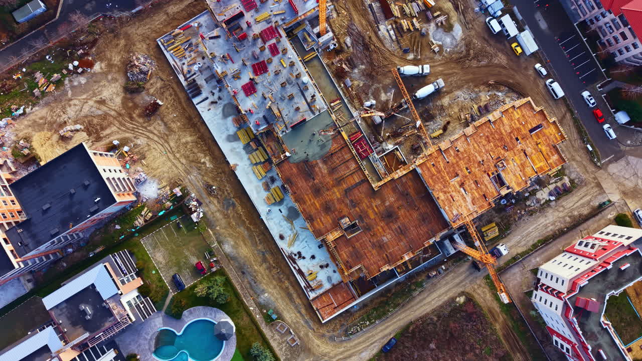 Baustelle mit Kränen und Gebäudestrukturen in einer Stadt während der Tagesstunden, die den Fortschritt eines neuen Projekts und die Umgebung zeigt
