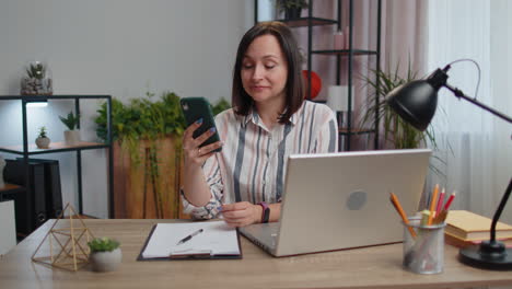 Young-businesswoman-working-with-smartphone-online-remote-distance-job-education-from-home-office