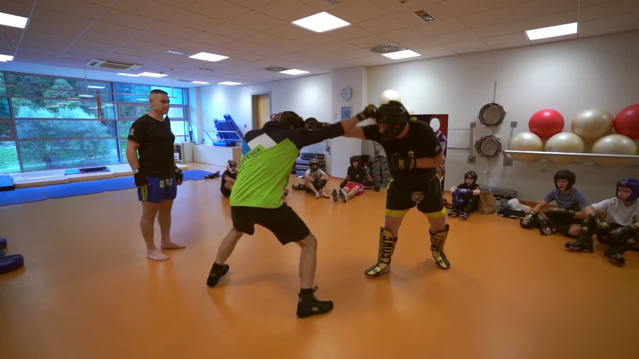 Slow motion  video of a young boxer.. Activity children training for boxing game. Boxer trainer with children. Young men playing boxing