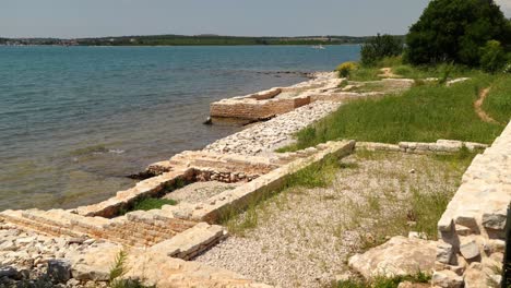 vegetation covers roman villa ruins as sea water erodes the foundations