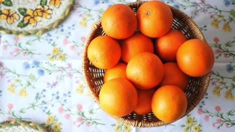 oranges in a basket on a floral tablecloth